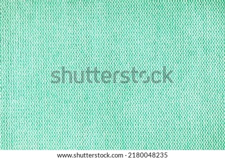 Close-up texture of natural turquoise coarse weave fabric or cloth. Fabric texture of natural cotton or linen textile material. Blue canvas background. Decorative fabric for upholstery, furniture