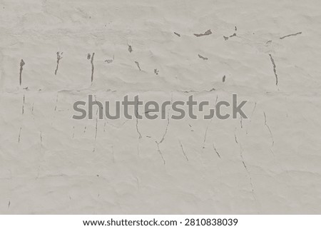 Close-up texture of an old, weathered plaster wall with significant cracking, crazing, and areas where the top layer of paint is peeling away, Estonia, Europe.