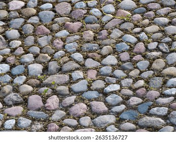 Close-up texture pattern of weathered natural stone cobblestone pavement with varied colored rocks