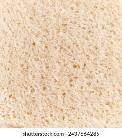 Close-up texture of a piece of white bread, emphasizing its porous surface and airy crumb for culinary contexts.