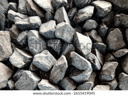 Close-up texture of rough, dark grey gravel stones. Ideal for construction, landscaping, or abstract background use. #GravelTexture #ConstructionMaterials #StoneBackground #IndustrialAggregate
