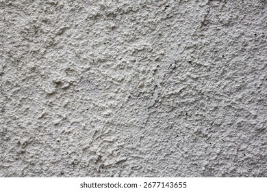 Close-up texture of rough gray plaster wall surface, ideal for backgrounds, construction, design, grunge themes, and abstract patterns.