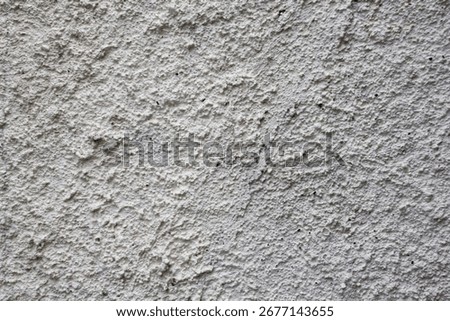 Close-up texture of rough gray plaster wall surface, ideal for backgrounds, construction, design, grunge themes, and abstract patterns.