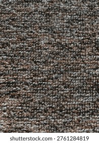 A close-up, textured background of a brown and grey carpet.