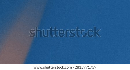 a close-up of a textured blue surface with a diagonal streak of light and shadow, capturing the subtle interplay of color and material grain