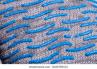 Close-up of textured fabric with blue rubber grip pattern