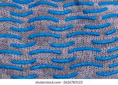 Close-up of textured fabric with blue rubber grip pattern