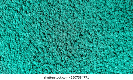 A close-up of textured green carpet or fabric surface for background 