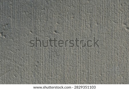 A close-up of a textured, light gray surface with small, evenly spaced indentations.