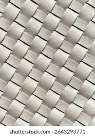 Close-up textured pattern, leather weave technique, intricate pattern diagonally woven strips, distinct tactile surface, fashion handbag accessories, gray leather  interwoven textured backdrop art