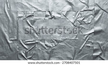 Close-up textured surface of overlapping silver duct tape strips creating a rugged, industrial background
