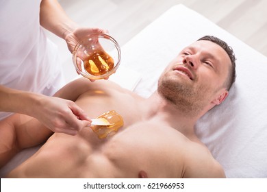 Close-up Of A Therapist Applying Wax On Man's Body - Powered by Shutterstock