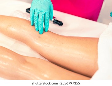 A close-up of a therapist's gloved hand performing a massage on a client's legs during a wellness session. Ideal for spa, self-care, and therapy-related concepts. - Powered by Shutterstock