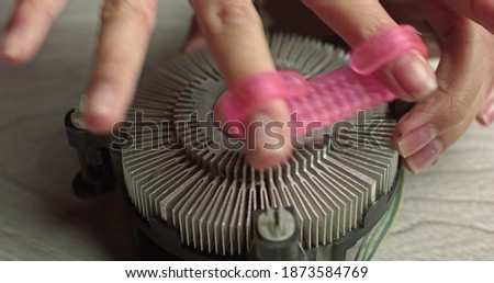 Close-up of thermal paste on the CPU cooling system. CPU cooling system thermal grease close-up macro studio shot. Removing thermal paste with cotton from heatsink.