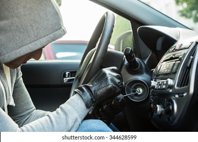 Close-up Of Thief Using Tool To Steal Car