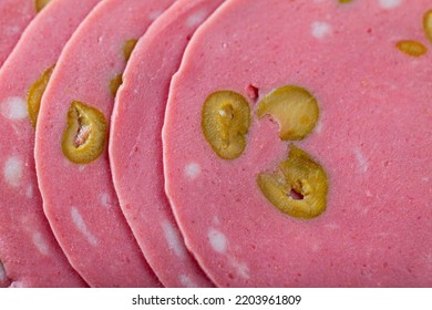 Closeup Of Thin Slices Of Appetizing Mortadella Sausage From Finely Ground Pork With Olives. Natural Food Background..