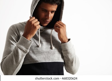 Closeup Of A Thoughtful-looking African American Model In Plain Cotton Heather Gray And Black Hoodie Looking Down And Holding His Hands Up To Put On The Hood Over His Head.