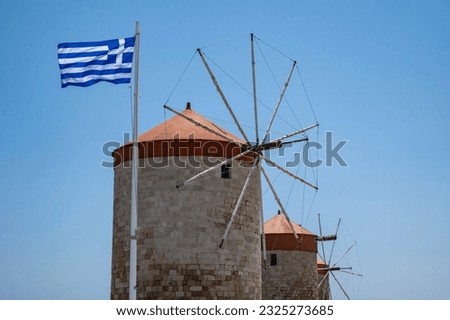 Closeup of the Three Ancient Windmills and the Greek Flag Against the Blue Sky Near the Harbor of Rhodes, Greece