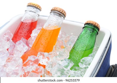 Closeup Of Three Different Soda Bottles In A Small Cooler Full Of Ice Cubes.