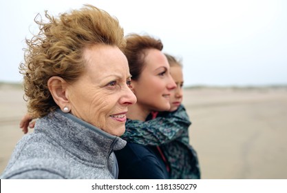 Closeup Of Three Generations Female Looking At Sea On The Beach In Autumn