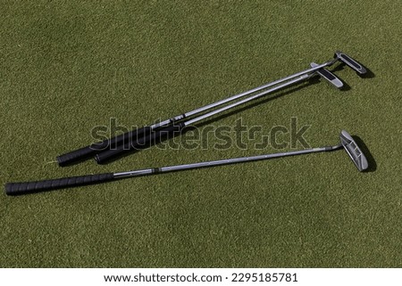 Close-up of three golf clubs on grass