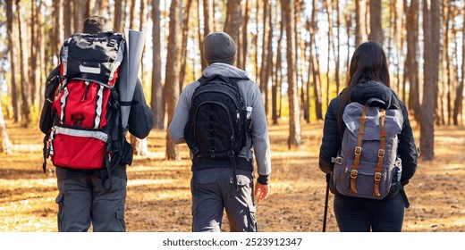 Closeup of three hikers walking by forest, spending weekend together outdoors - Powered by Shutterstock