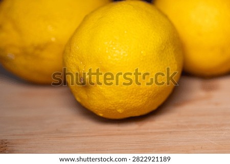 Close-up of three lemons on a cutting board, subtropical fruit. Contains vitamin C, freshness, citrus fruit, healthy eating.