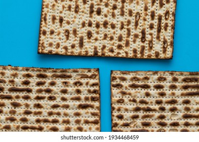 A close-up of three matzahs - bread for the Jewish Passover, on a light blue background