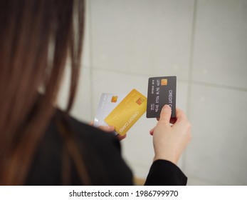 Close-up Of Three Mockup Credit Cards In A Businesswoman's Hands, A Rear View Of A Businesswoman In A Black Suit Is Holding Three Mockup Credit Cards In Her Hands.