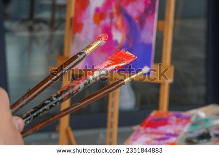 Close-up of three painting brushes of different sizes in paint the concept of admiration for oil painting