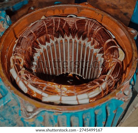 Close-up of three phase electric motor stator with copper winding after rewinding process in industrial workshop.