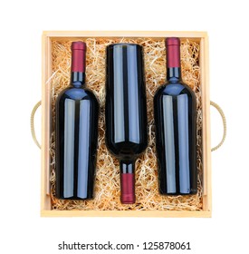 Closeup Of Three Red Wine Bottles In A Wooden Case With Packing Straw. Overhead Shot On A White Background.