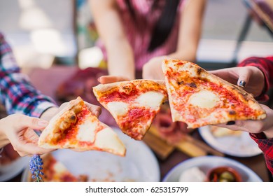 Close-up Three Slices Of Pizza Which People Keep Beyond The Table In A Restaurant