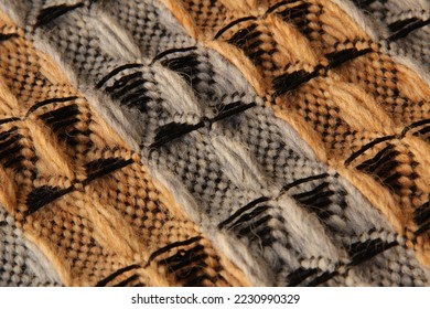 Closeup of threedimensional waffle weave pattern in orange and grey