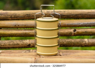 Closeup Of Tiffin Carrier On Bamboo Bench.