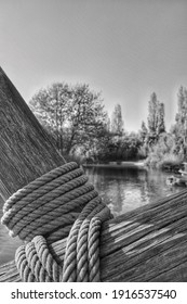 A Closeup Of A Tight Rope Around A Wooden Construction, Outdoors In Black And 