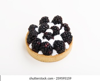 close-up of a tiny tart with black raspberry on top isolated on white background