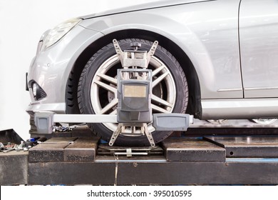 Closeup Of Tire Clamped With Aligner Undergoing Auto Wheel Alignment In Garage