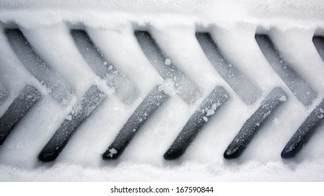 A Closeup Of The Tire Print Of A Truck In Snow