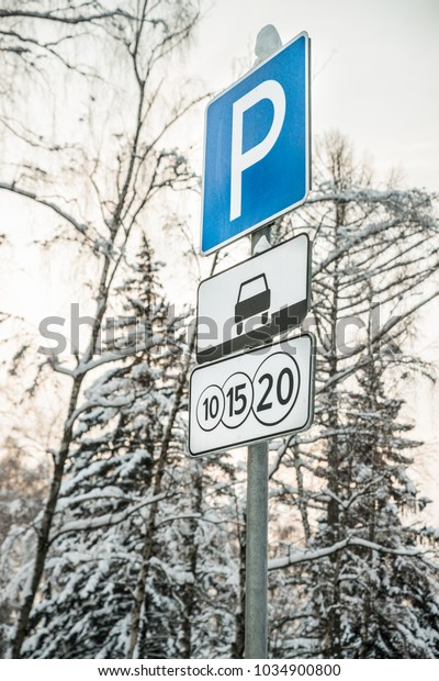 A closeup of a toll road street sign on the\
background of winter trees