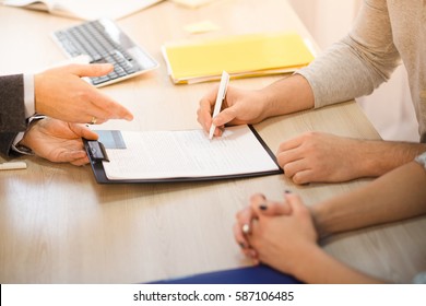 Closeup toned of man signing agreement or contract for getting new credit card represented by salesman or businessman. Contract for buying apartment, flat, car.
