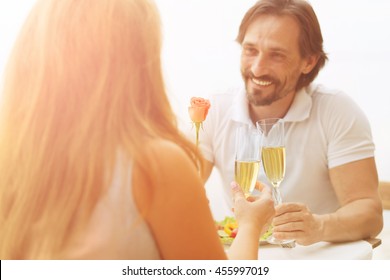 Closeup toned picture of handsome man smiling to his woman while spending time in restaurant or cafe. Beautiful people having lunch or dinner. - Powered by Shutterstock