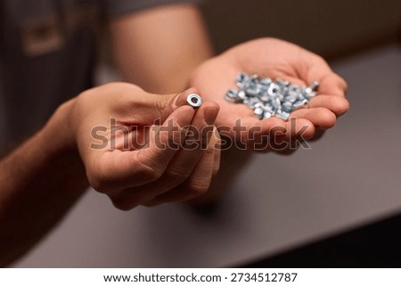Closeup of tools and craftsmanship. Focus on detailed hand positioning and metal work. Intimate shot emphasizing precision in smallscale metal assembly craftsmanship