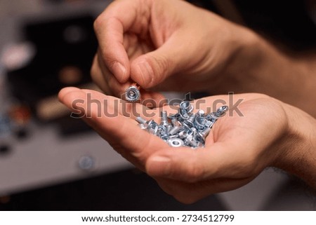 Closeup of tools and craftsmanship. Focus on detailed hand positioning and metal work. Intimate shot emphasizing precision in smallscale metal assembly craftsmanship
