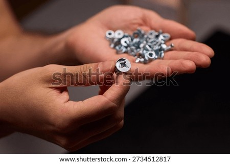 Closeup of tools and craftsmanship. Focus on detailed hand positioning and metal work. Intimate shot emphasizing precision in smallscale metal assembly craftsmanship