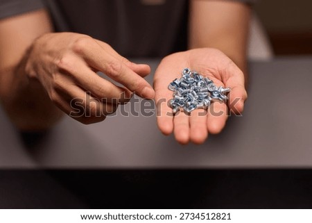 Closeup of tools and craftsmanship. Focus on detailed hand positioning and metal work. Intimate shot emphasizing precision in smallscale metal assembly craftsmanship