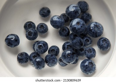 Closeup Top View Above Soaking Heap Group Fresh Organic Picked Blueberries With Cold Water Mixed Vinegar In A White Bowl Background. Washing For Reduce And Remove Bacterial Before Eating Concept