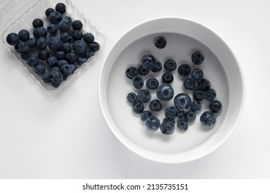 Closeup Top View Above Soaking Heap Group Fresh Organic Picked Blueberries With Cold Water Mixed Vinegar In A White Bowl Background. Washing For Reduce And Remove Bacterial Before Eating Concept