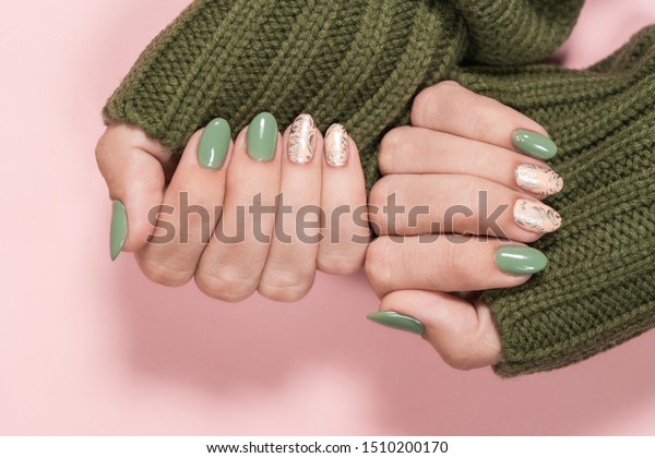 パステルピンクの背景に光沢のある銀印デザインの緑とピンクの爪の 美しい2色の色あせたトレンディのマニキュアの接写 秋冬風のネイルデザインコンセプト の写真素材 今すぐ編集