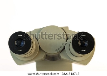 Close-up top view of binocular microscope eyepieces with interpupillary distance adjustment. Professional optical laboratory equipment isolated on a white background.